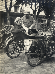 811863 Afbeelding van W.H.J. Bruschwiler en zijn vrouw L. Bruschwiler - Plett bij hun motor met zijspan.